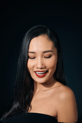 Fototapeta premium Face of the beautiful woman with long hair posing at studio over dark background