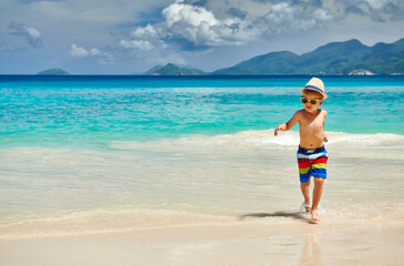 Fototapeta na wymiar Three year old toddler boy walking on beach