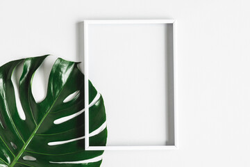 Summer composition. Tropical leaf, photo frame on white background. Summer concept. Flat lay, top view, copy space