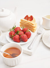 Strawberries and pancakes. Pancakes with strawberries. Romantic breakfast. Valentine's Day. Greeting Card Mother's Day. Breakfast in hotel room. Maslenitsa. Pancake week. Women's Day Congratulation