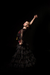 elegant dancer with hand on hip dancing flamenco isolated on black