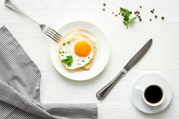 Fried eggs sandwich on plate - white dinner table top view