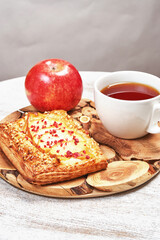 Still life with cake, tea and red apples on a light background