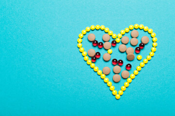 Symbol heart from colors  pills medicament and different pills inside on blue background 