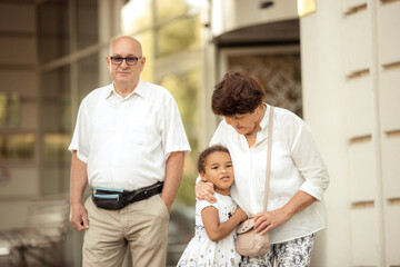 Fototapeta premium Grandparents playing with their granddaughter