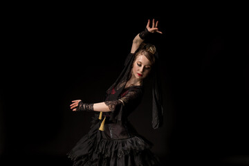 beautiful dancer looking down while dancing flamenco isolated on black - obrazy, fototapety, plakaty