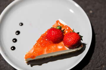 Close up of strawberry cheese cake slice on a plate