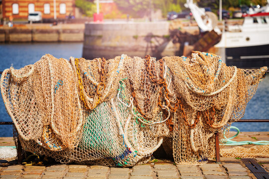 Fisherman nets drying on the sun in the port barrier near the sea