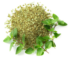 dried oreagon flakes with fresh oregano leaves isolated on white background, top view