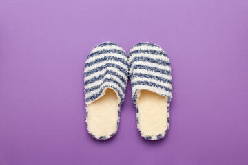 Two striped home slippers isolated on purple background 
