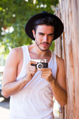 Hipster young man with vintage camera outdoors
