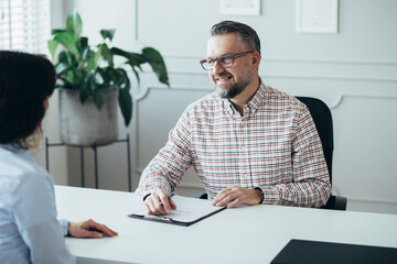 Handsome senior boss interviewing an elegant business woman