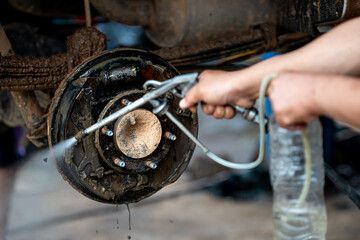 Old rusty brake system in the car have to clean with high pressure water gun.