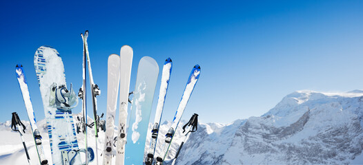 Many ski and snowboard mountain equipment over the sky with summit peak - Powered by Adobe