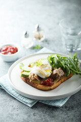 Poached egg with tuna and arugula on toast