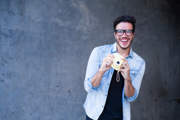Man with trendy outfit and vintage camera