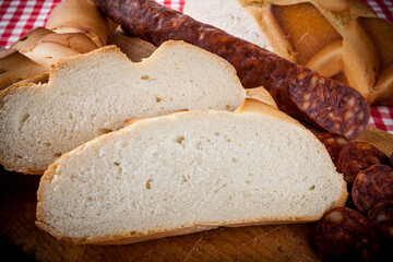 rebanadas colón candeal pan artesano con decoración chorizo sobre mantel de cuadros rojos