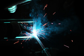 Fototapeta na wymiar Sparks from welding. A man will weld metal. Workplace of the welder. Garage welder