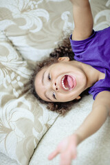 Cheerful small girl showing her tongue.