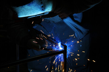 Sparks from welding. A man will weld metal. Workplace of the welder. Garage welder