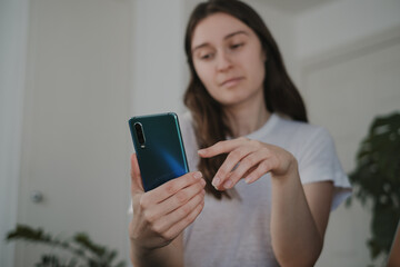 young freelancer woman texting on mobile phone working from home
