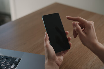Young woman typing on her smartphone closeup