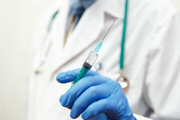 Doctor in gloves holding a medical injection syringe