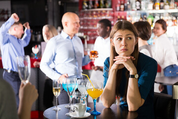 Upset young woman at corporate bar party