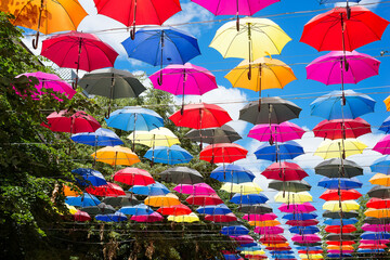 Fototapeta na wymiar Colorful umbrellas background. Colorful umbrellas in the sky. Street decoration.