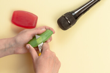 ASMR concept. Specific auditory irritants. Woman hands cut soap in front of the microphone. Top...