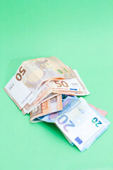 A lot of money saved to spend the holidays. Paper money on a green background. The green hope