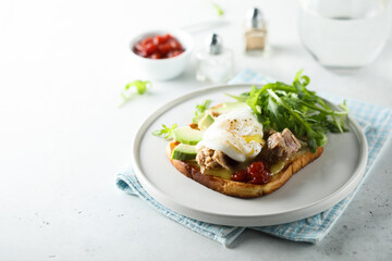 Poached egg with tuna and arugula on toast
