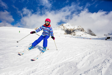 Portrait in motion of a girl doing alpine ski excurse mowing downhill