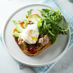Poached egg with tuna and arugula on toast