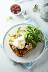 Poached egg with tuna and arugula on toast
