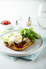 Poached egg with tuna and arugula on toast