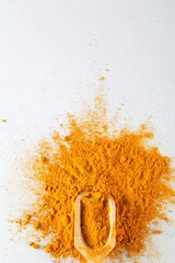 turmeric powder in wood spoon on gray background