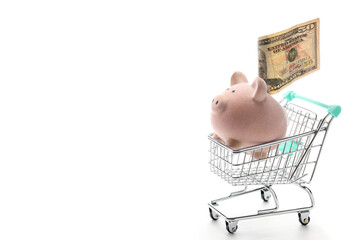 Toy pink piggy bank inside shopping cart isolated on white background 