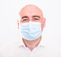 portrait of bald adult elderly man in medical mask with emotions on white background