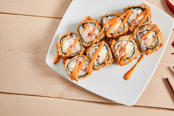 Rolls with shrimps, cream cheese, tomatoes and Spicy sauce in white plate top view