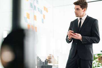 Image of concentrated young businessman using stickers while working