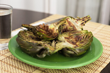 cooked fried halves artichokes on green plate