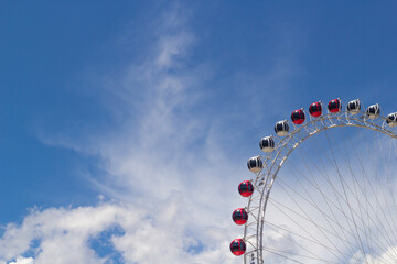 Ferris wheel cabins amusement park, cloudy sky in background