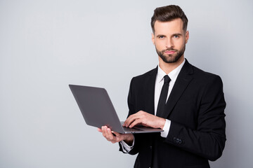 Portrait of confident successful entrepreneur man use laptop work on start-up project chat with clients partners wear formalwear clothing isolated over grey color background