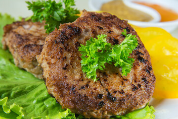Cutlet with sauce and herbs on a white background
