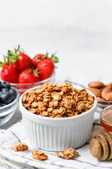Homemade oatmeal granola bowl with berries on white background.