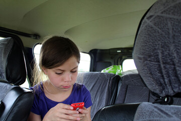 a child with a gadget in a car