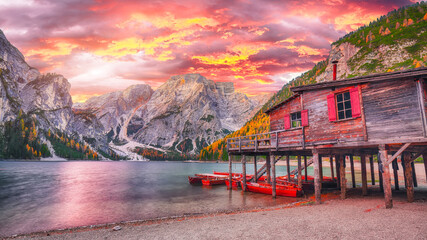 Dramatic scenery of famous alpine lake Braies at autumn during sunset.