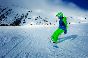 Action dramatic portrait of a boy on snowboard ride downhill view from behind on the slope track