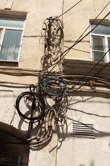 A lot of electric wires tangled together on the facade of a residential building